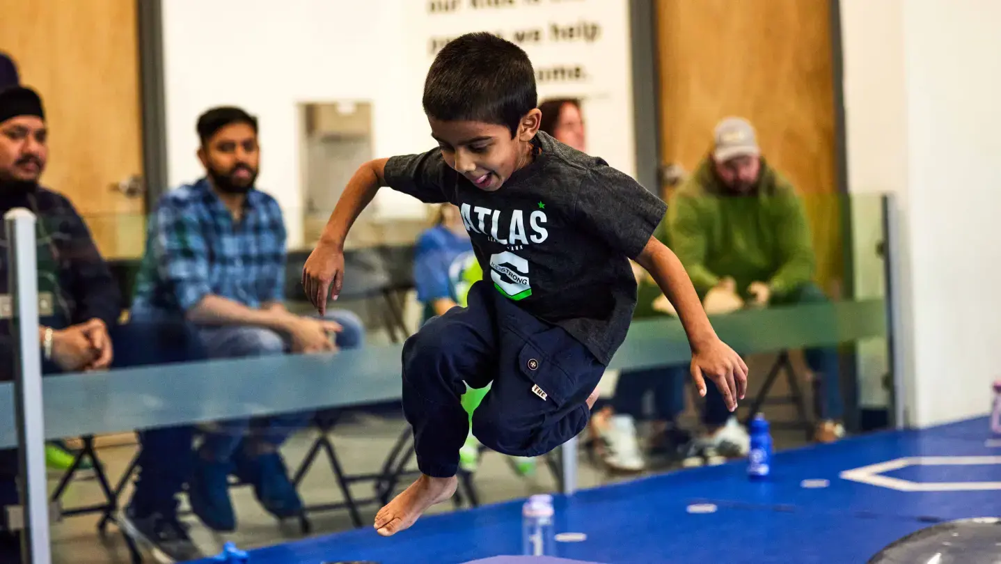 A mid-air action shot of a focused student jumping.